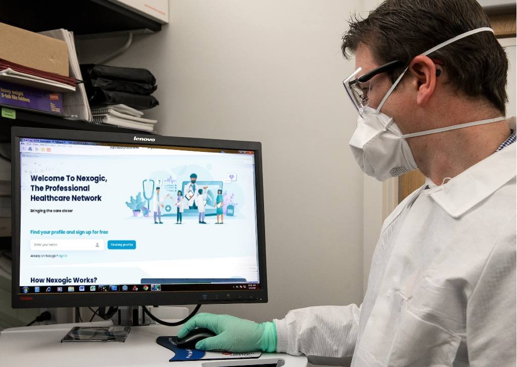 Person in lab coat using computer
